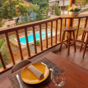 a table with a plate on a balcony with a pool at Residência Thomas in Itacaré