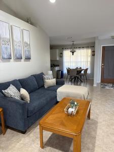 a living room with a blue couch and a table at Seras Home At Vero Beach in Vero Beach