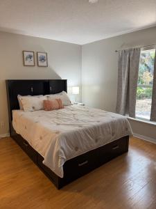a large bed in a bedroom with a large window at Seras Home At Vero Beach in Vero Beach