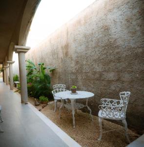 a table and two chairs sitting next to a wall at Petra By Ariché in Valladolid