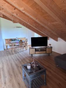 a living room with a tv and a table at Ferienwohnung Grecht in Uffing