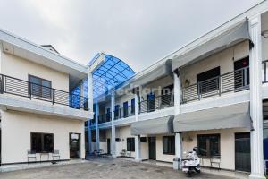 a building with a scooter parked in front of it at Wisma Merdeka Syariah RedPartner in Palembang