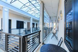 a balcony with blue chairs and a glass ceiling at Wisma Merdeka Syariah RedPartner in Palembang