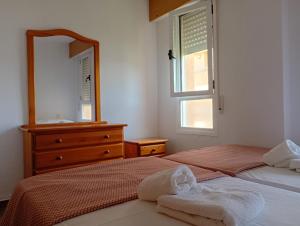 a bedroom with two beds and a mirror and a dresser at Edificio Mirasierra in Oropesa del Mar +92 photos