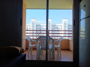 a table and chairs on a balcony with a view of a building at Edificio Mirasierra in Oropesa del Mar