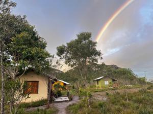 a rainbow in the sky over a house at Hospedaria Portal das Montanhas in Ibicoara