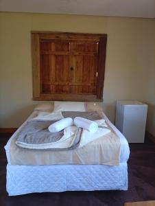 a bedroom with a bed with towels on it at Hospedaria Portal das Montanhas in Ibicoara