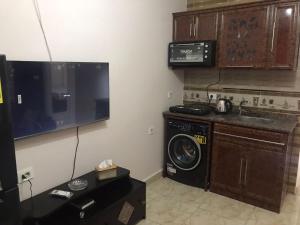 a laundry room with a washing machine and a tv at بورتوجولف portogolf in El Alamein