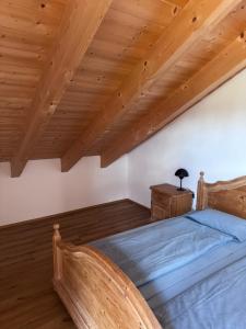 a bedroom with a bed and a wooden ceiling at Ferienwohnung Grecht in Uffing