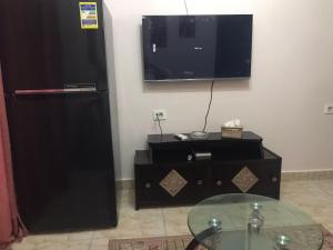 a living room with a tv and a glass table at بورتوجولف portogolf in El Alamein +4 photos