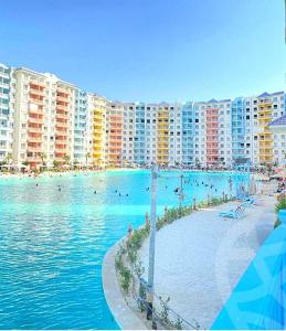 a large swimming pool with people in the water at بورتوجولف portogolf in El Alamein