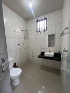 a bathroom with a toilet and a sink at Hostel Coimbra Araçagi in Macajatuba