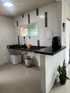 a kitchen with a black counter top in a room at Hostel Coimbra Araçagi in Macajatuba +14 photos