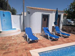 a group of blue chairs next to a swimming pool at Monte Madalena in Querença