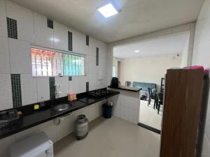 a kitchen with a sink and a counter top at Hostel Coimbra Araçagi in Macajatuba