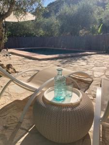a glass bottle sitting on top of a wicker table at Cabaña La Pura Vida Yunquera in Yunquera