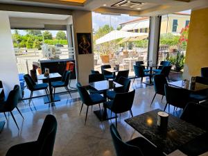 a restaurant with tables and chairs and a large window at Santa Caterina Park Hotel in Sarzana