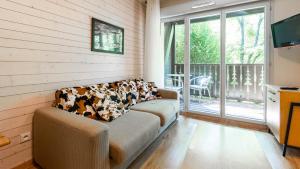 a living room with a couch and a television at Les Chalets d Ax N120 2P6 in Ax-les-Thermes