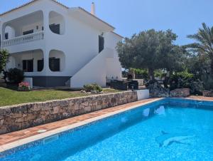 a villa with a swimming pool in front of a house at Monte Madalena in Querença