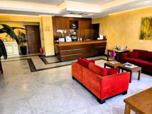 a lobby with a red couch and a counter at Santa Caterina Park Hotel in Sarzana