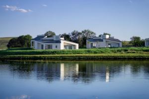 two houses on an island next to a body of water at Things grow in their native land in Ulanqab