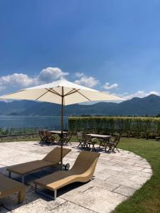 a patio with a table and chairs and an umbrella at franciacorta iseo lake house in Clusane sul Lago