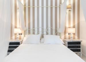 a bedroom with a white bed and two night stands at Casa en el Roc de Sant Gaieta in Roda de Bará