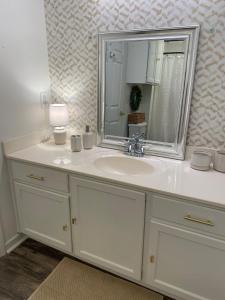 a bathroom with a white sink and a mirror at Lucky 13 Condo in Starkville +15 photos