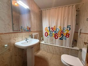 a bathroom with a sink and a shower curtain at La dorada 8 in Torroella de Montgrí