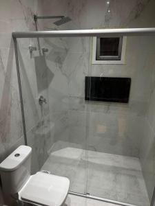 a bathroom with a shower and a white toilet at Arruda UMARI in Benevides
