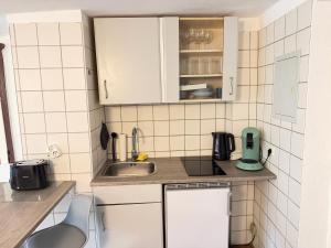 a small kitchen with white cabinets and a sink at Gemütliches Studio direkt am Marktplatz Boppard in Boppard