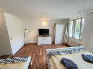 a bedroom with two beds and a flat screen tv at Gemütliches Studio direkt am Marktplatz Boppard in Boppard +1 photo
