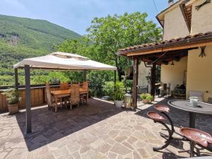 a patio with an umbrella and a table and chairs at Bed & Breakfast SENTIERO 54 in Cantiano