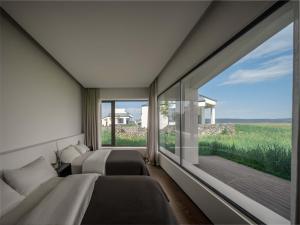 a bedroom with two beds and a large window at Things grow in their native land in Ulanqab
