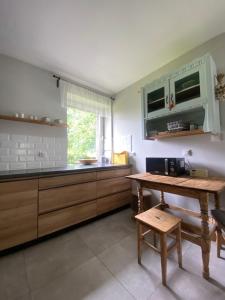 a kitchen with a wooden table and a microwave at Folwark Mazurskie Legendy - Azyl dla Dorosłych in Kruklanki +41 photos