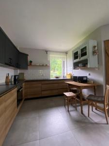 a kitchen with wooden cabinets and a table in it at Folwark Mazurskie Legendy - Azyl dla Dorosłych in Kruklanki