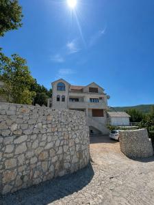 a large house with a stone wall in front of it at Darinka in Ulcinj