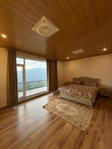 a bedroom with a bed and a large window at The Elysian Villa in Murree