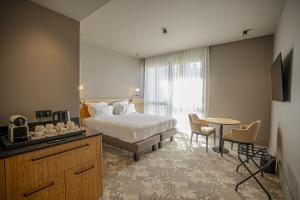 a hotel room with a bed and a table and chairs at La Chapelle in Annecy