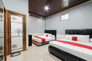 a bedroom with two beds and a window at RedDoorz Lotte near PTC MALL in Palembang