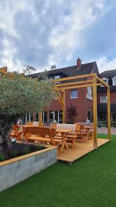 a wooden pergola with a picnic table on a deck at Hotel Pelikan in Papenburg
