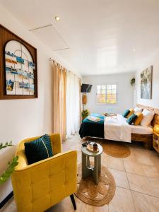 a bedroom with a bed and a couch and a chair at Le SeaZen Lodge in Sainte-Anne