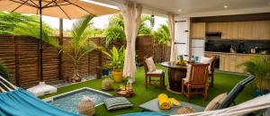 a patio with a hammock and a table and a kitchen at Le SeaZen Lodge in Sainte-Anne