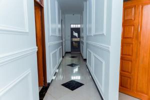a hallway with a door and a tile floor at Pakihotels&apartment in Moshi