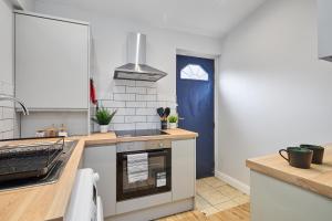 a kitchen with a sink and a stove top oven at Cosy Two Bed House (16BLR) in Leeds