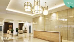 a lobby with a reception desk and chandeliers at Siena Tower - Gian's Nook in Manila +20 photos