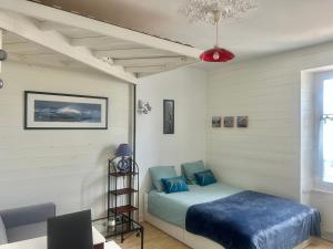 a bedroom with a bed and a table and a ceiling at Studio -Center - Lorient in Lorient