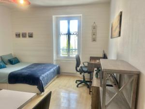 a bedroom with a bed and a desk with a computer at Studio -Center - Lorient in Lorient +4 photos