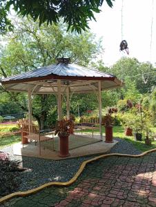 a wooden pavilion with a bench and an umbrella at Ella Garden Resort in Mag-ag