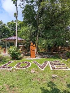 a garden with a statue in the grass at Ella Garden Resort in Mag-ag